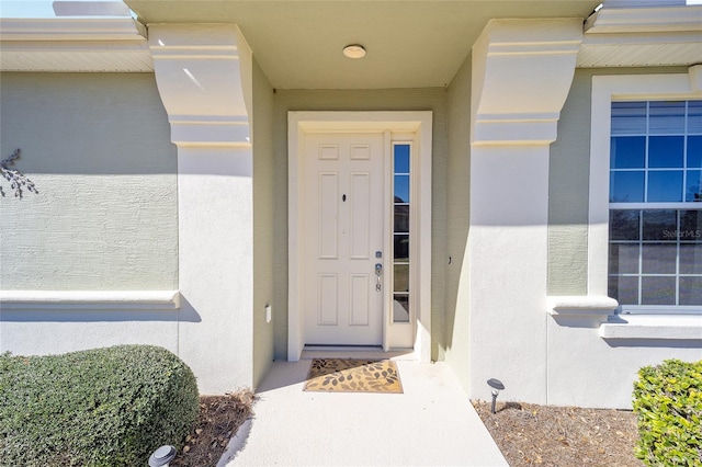 doorway to property featuring stucco siding