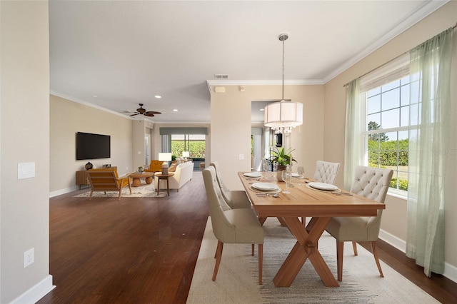 dining room with ornamental molding, wood finished floors, visible vents, and baseboards