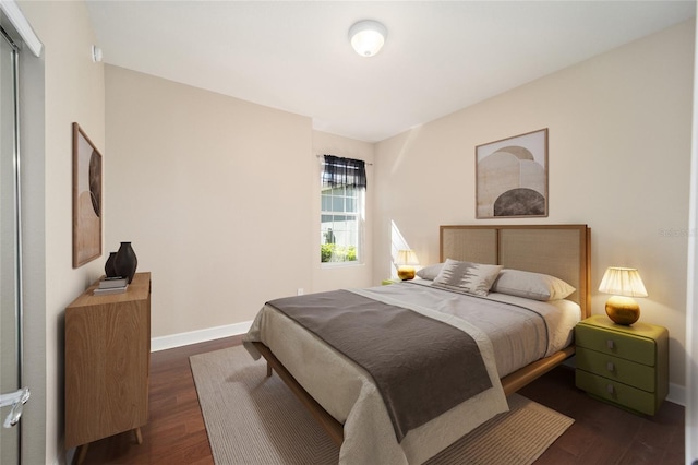 bedroom with dark wood finished floors and baseboards