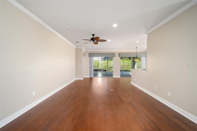 spare room featuring ornamental molding, baseboards, and wood finished floors