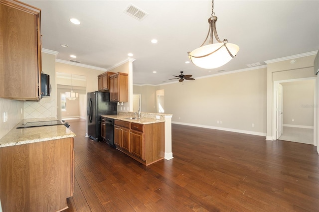 kitchen featuring black appliances, visible vents, brown cabinets, and a sink