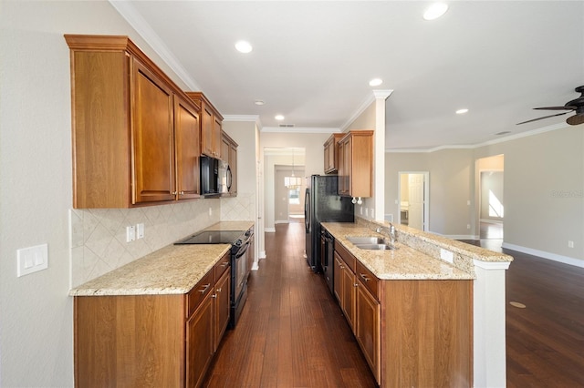 kitchen with dark wood finished floors, ornamental molding, a sink, light stone countertops, and black appliances