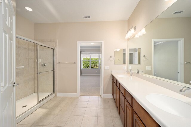 bathroom with a stall shower, tile patterned flooring, a sink, and visible vents