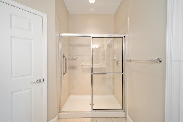 bathroom with a stall shower and tile patterned floors