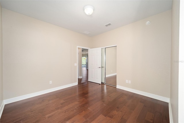 unfurnished room with visible vents, baseboards, and wood finished floors