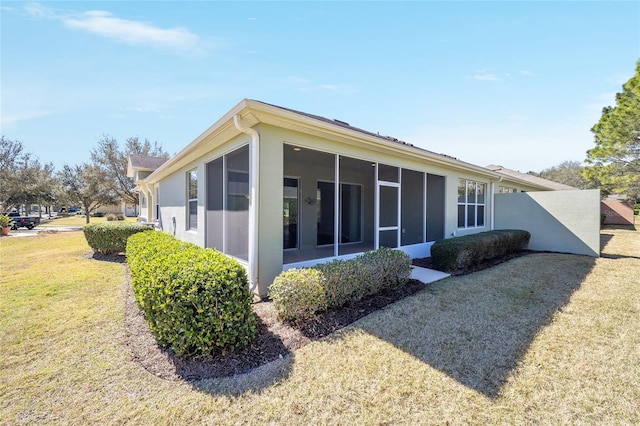 back of property featuring a sunroom and a yard