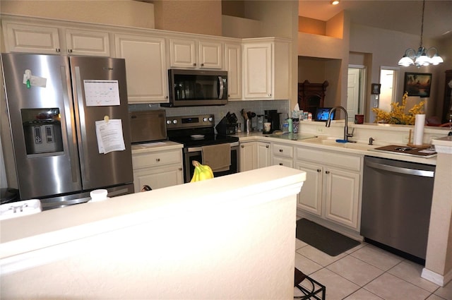 kitchen featuring decorative light fixtures, light tile patterned floors, stainless steel appliances, light countertops, and a sink