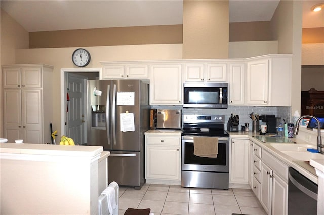 kitchen with a sink, white cabinetry, light countertops, appliances with stainless steel finishes, and decorative backsplash