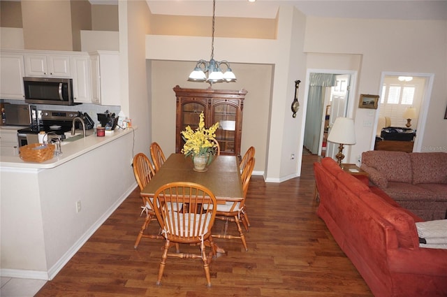 dining room featuring a chandelier, dark wood-style flooring, and baseboards