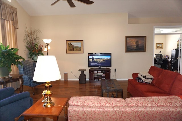 living area featuring a ceiling fan, dark wood-style flooring, and baseboards