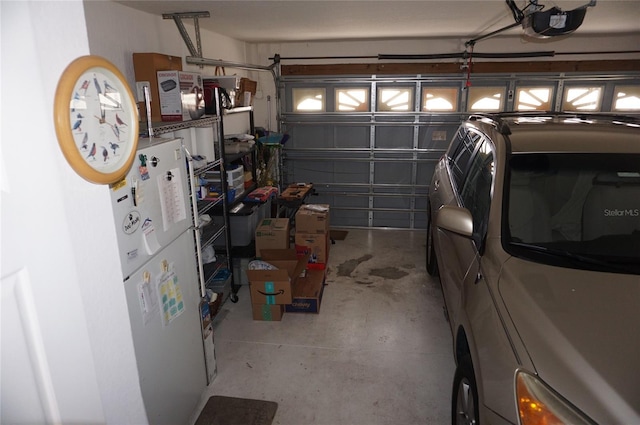 garage with freestanding refrigerator and a garage door opener