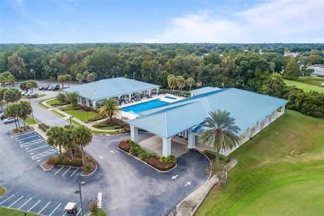 bird's eye view of a pool and a heavily wooded area