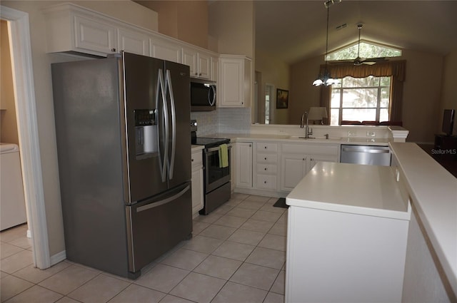 kitchen featuring appliances with stainless steel finishes, light tile patterned floors, lofted ceiling, white cabinetry, and a sink