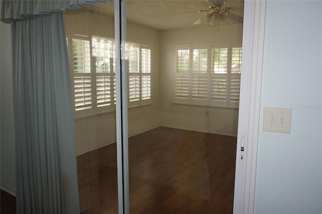 unfurnished room with a ceiling fan, wood finished floors, and baseboards