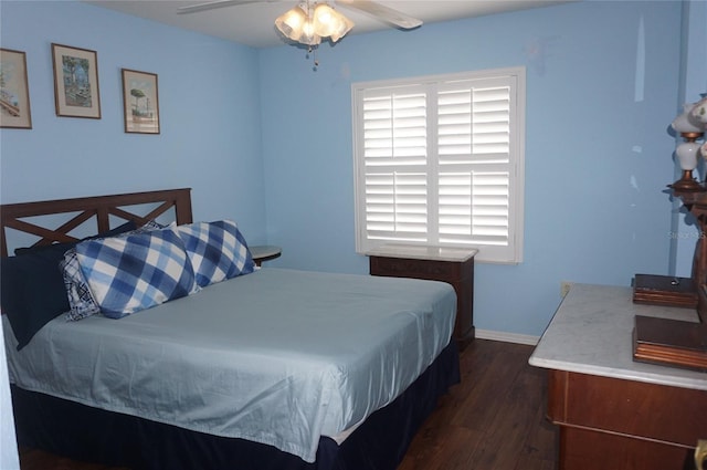bedroom featuring dark wood-type flooring, baseboards, and a ceiling fan