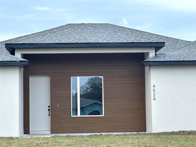 view of home's exterior with roof with shingles and stucco siding