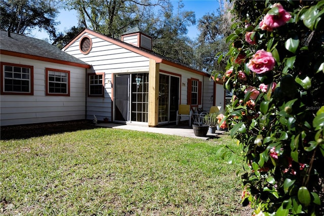 rear view of house with a patio and a yard