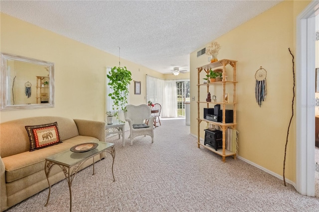 living room with carpet, ceiling fan, and a textured ceiling