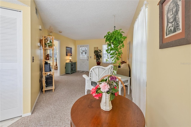 carpeted dining room featuring a textured ceiling