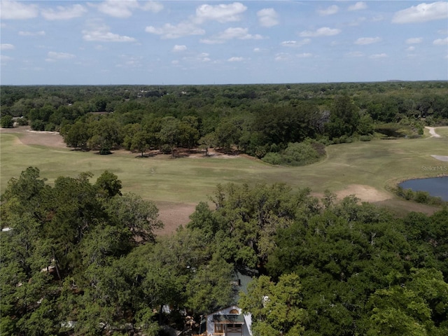 drone / aerial view featuring golf course view, a forest view, and a water view