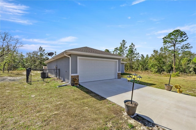 exterior space with central AC unit, a garage, and a lawn