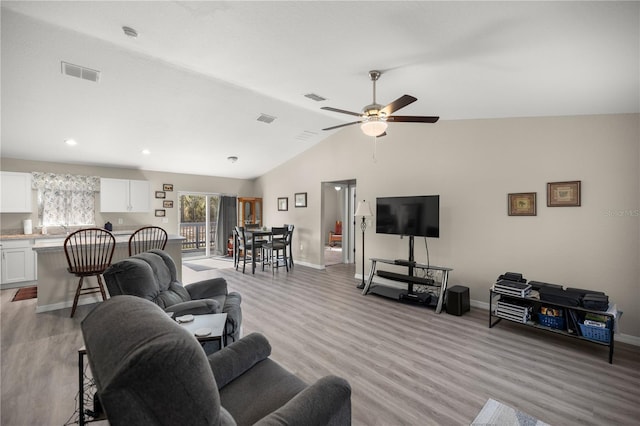 living room with light wood-type flooring, vaulted ceiling, and ceiling fan