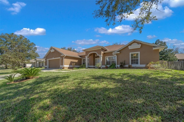 view of front of house with a garage, a front yard, fence, and stucco siding