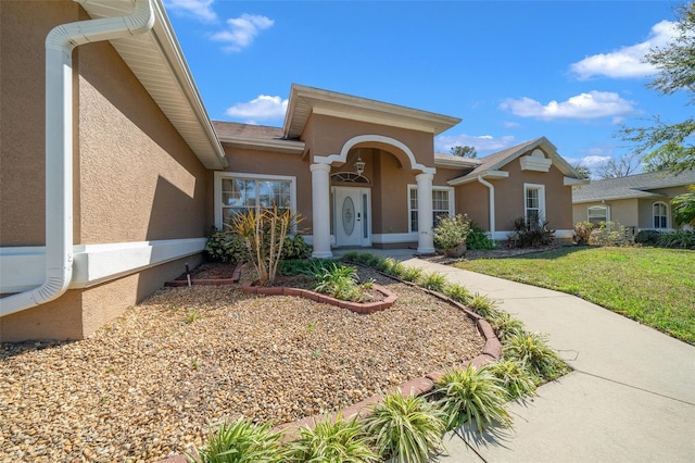 view of front of house with a front lawn and stucco siding