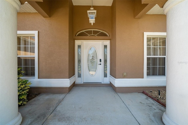 entrance to property featuring stucco siding