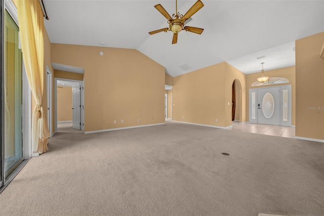 unfurnished living room featuring arched walkways, light colored carpet, a ceiling fan, high vaulted ceiling, and baseboards