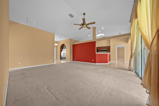 unfurnished living room featuring arched walkways, light carpet, visible vents, a ceiling fan, and vaulted ceiling