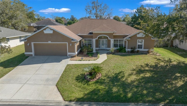 view of front of home with an attached garage, driveway, a front lawn, and stucco siding