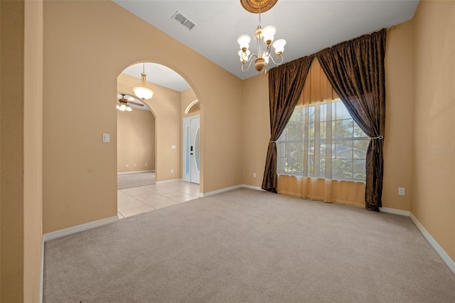 empty room featuring arched walkways, a chandelier, light carpet, visible vents, and baseboards