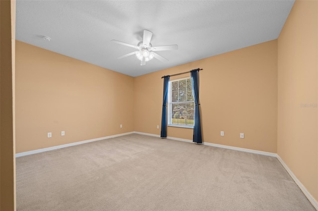 empty room featuring light carpet, ceiling fan, baseboards, and a textured ceiling