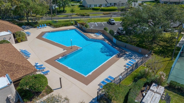 community pool featuring fence and a patio