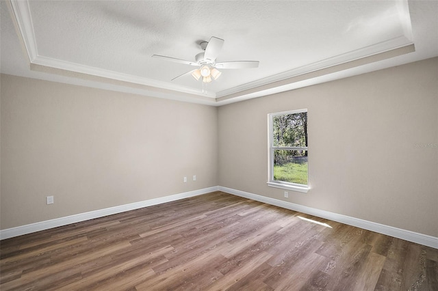 unfurnished room with a raised ceiling and wood finished floors