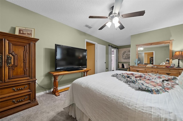 bedroom with a textured ceiling, light colored carpet, a ceiling fan, baseboards, and visible vents