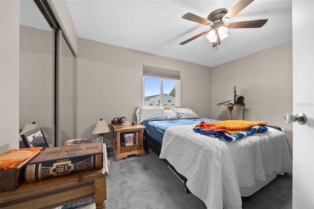 carpeted bedroom featuring a closet, ceiling fan, and a textured ceiling