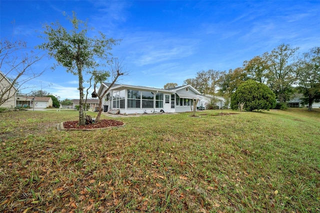 back of house with a sunroom and a yard