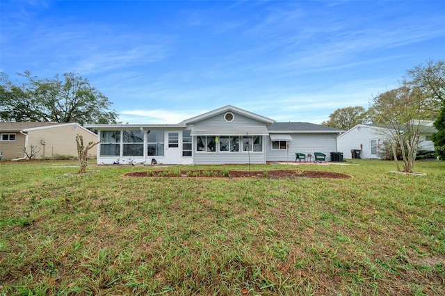 back of property with a lawn and a sunroom