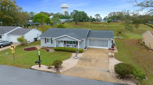 ranch-style house with covered porch, concrete driveway, a front lawn, and an attached garage