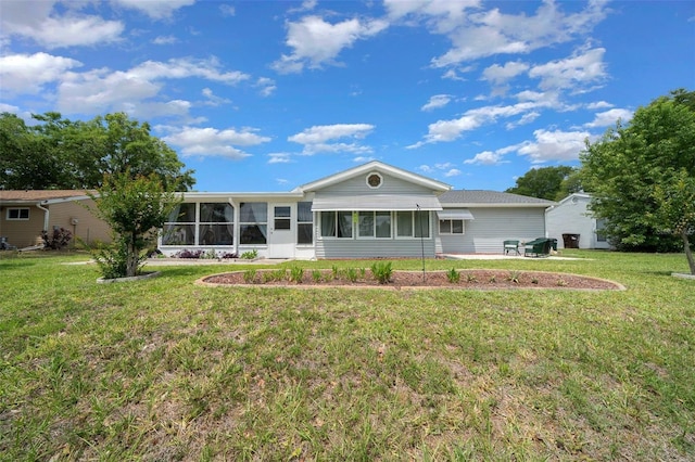 back of property with a yard and a sunroom