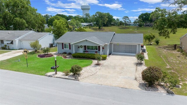 single story home featuring a porch, a garage, a front yard, and driveway