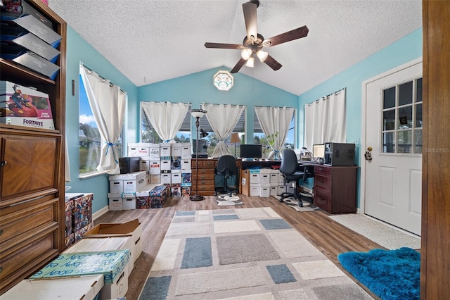 office space featuring a textured ceiling, vaulted ceiling, wood finished floors, and ceiling fan