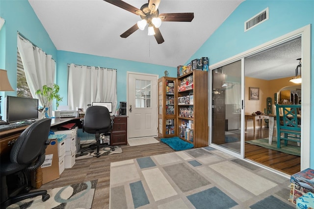 office featuring visible vents, wood finished floors, lofted ceiling, and ceiling fan