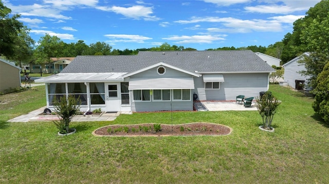 back of property featuring roof with shingles, a sunroom, a patio, and a lawn