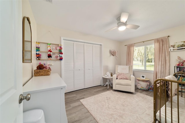 bedroom with a closet, light wood-style flooring, and a ceiling fan