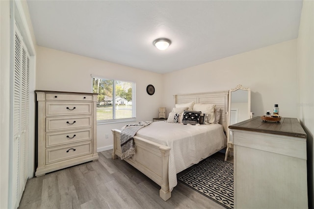 bedroom with light wood finished floors and baseboards