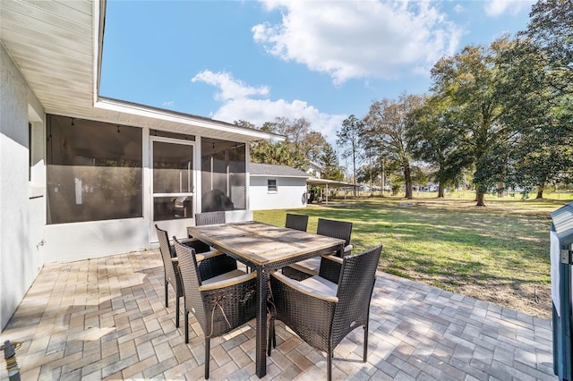 view of patio with a sunroom and outdoor dining space