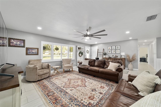 living room featuring baseboards, a ceiling fan, visible vents, and recessed lighting